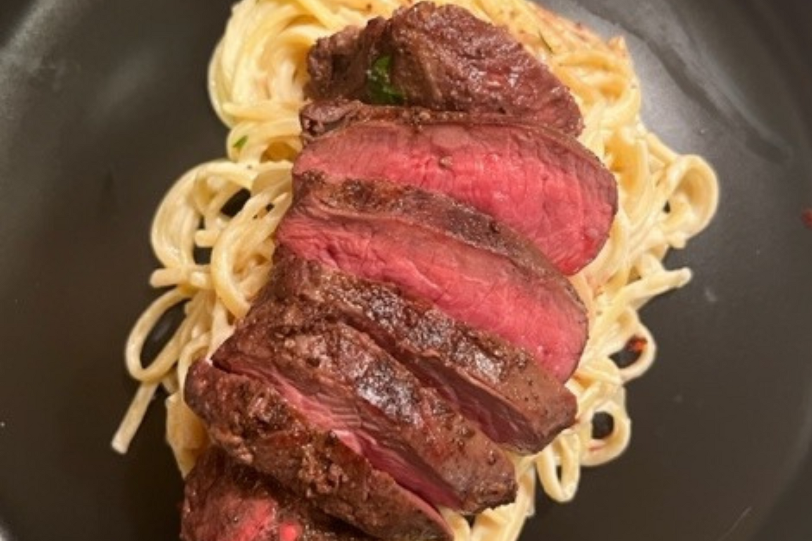 Ostrich steak on top of pasta