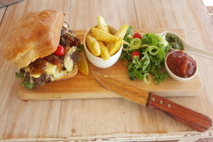ground ostrich steak burger with fries and a salad
