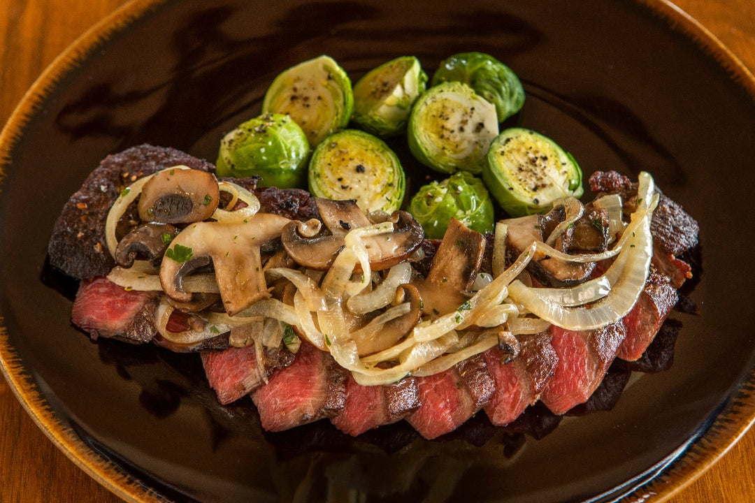 cooked and sliced ostrich tenderloin with onions and mushrooms