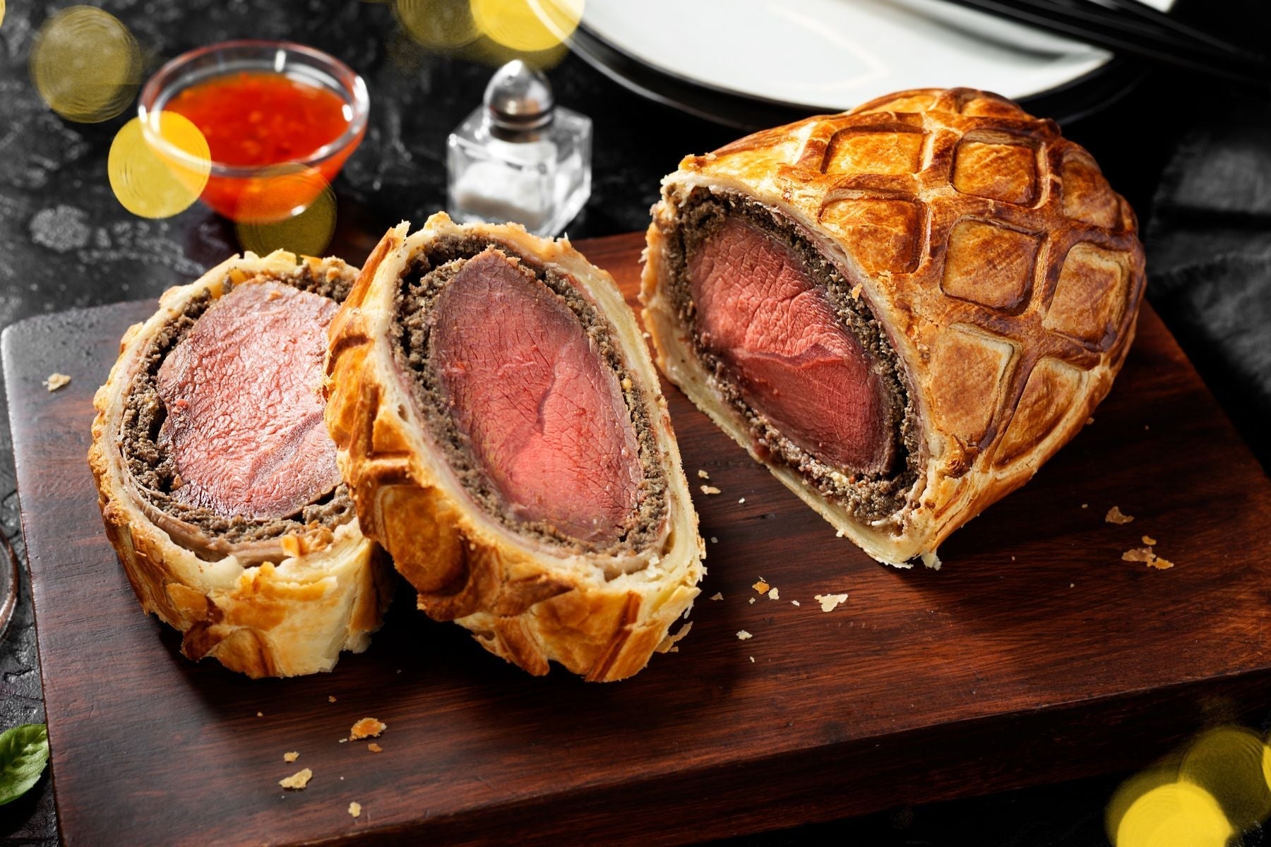 sliced ostrich wellington on a wooden cutting board