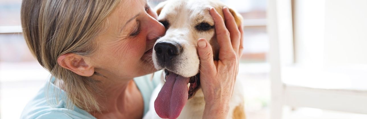 woman nuzzling a happy dog