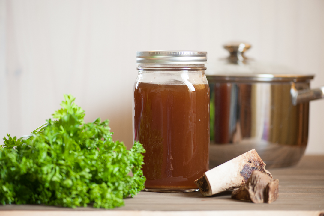 Ostrich bone broth in a jar with parsley