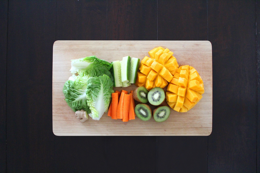 A cutting board filled with fruits and vegetables.