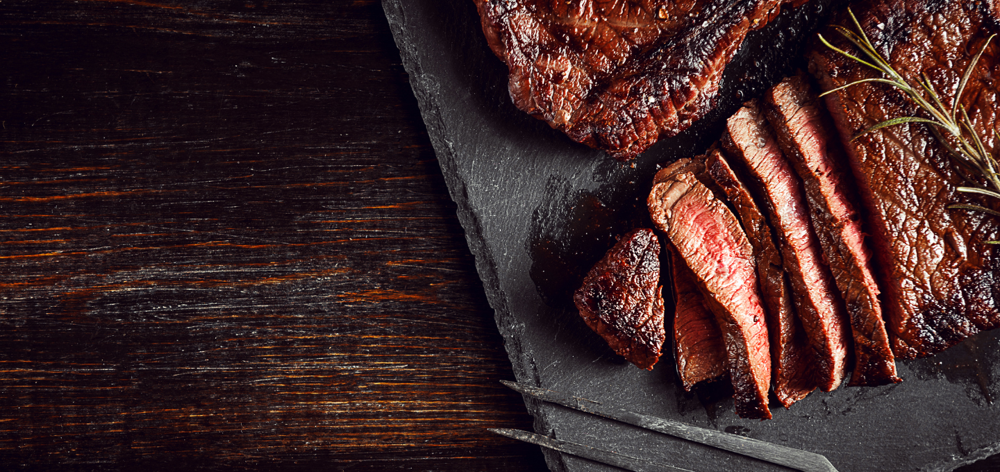 sliced ostrich steak over greens