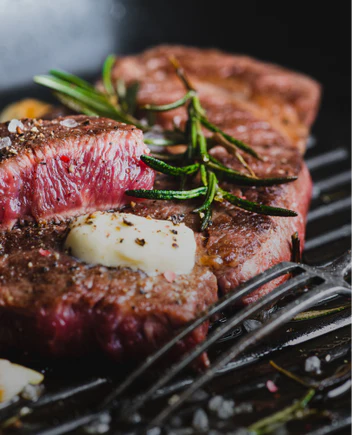 ostrich steak seared on the grill with butter and rosemary