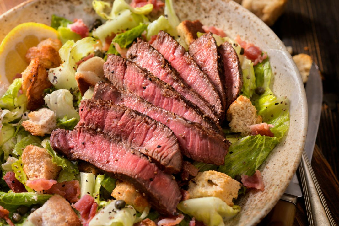 ostrich filet sliced on top of salad 