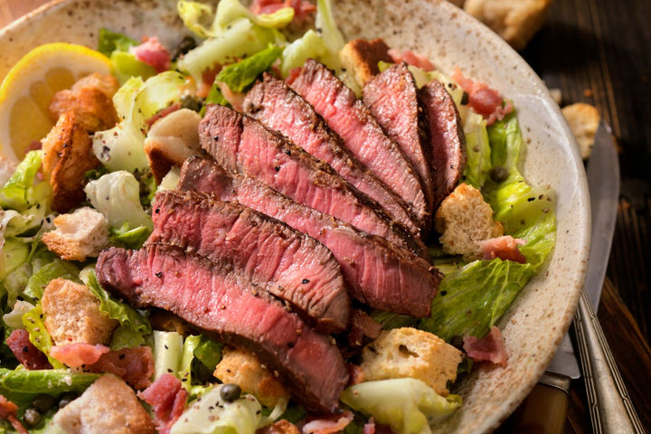 ostrich filet sliced on top of salad 