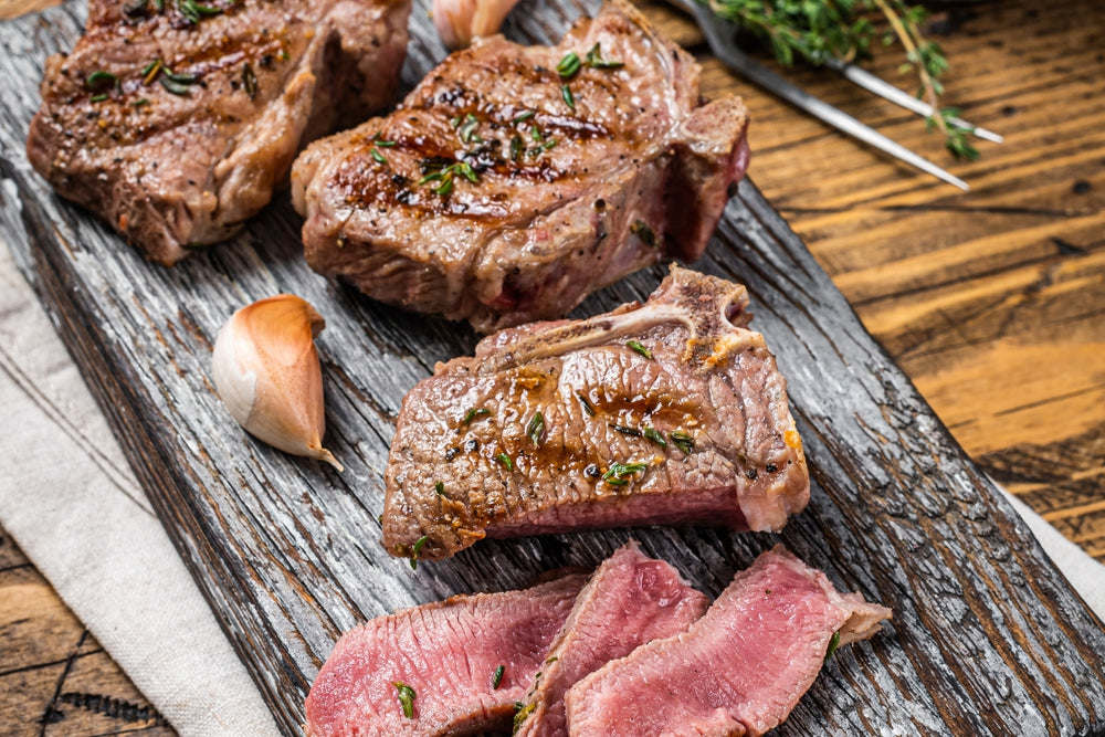 cooked lamb loin chops on a rustic cutting board