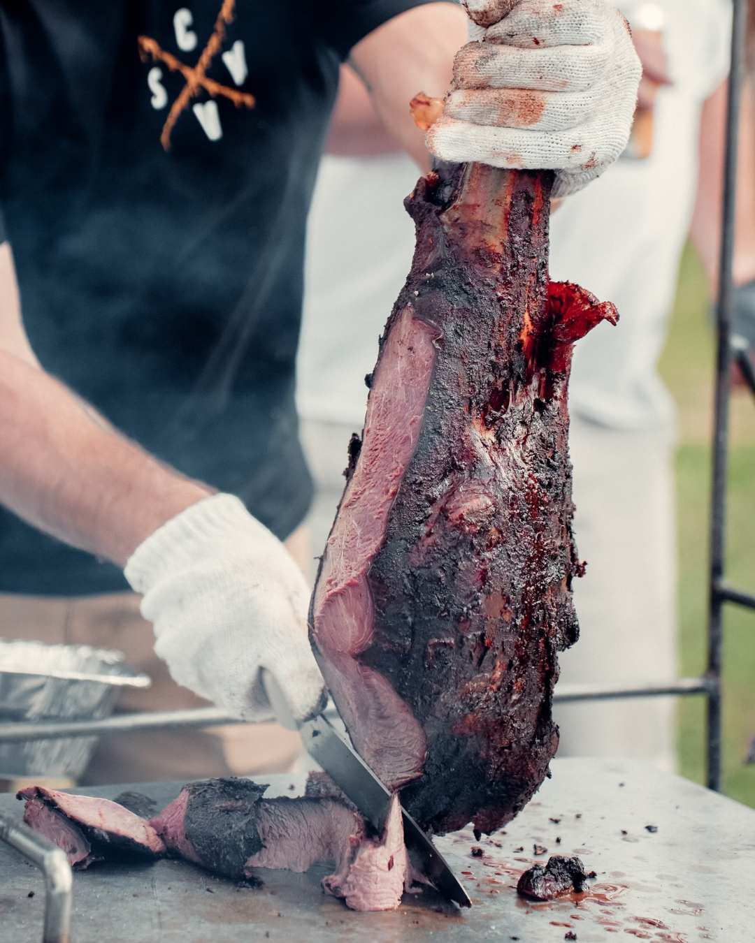 whole smoked ostrich leg being sliced