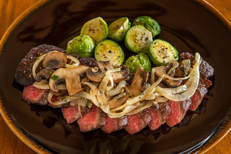 cooked and sliced ostrich tenderloin with onions and mushrooms