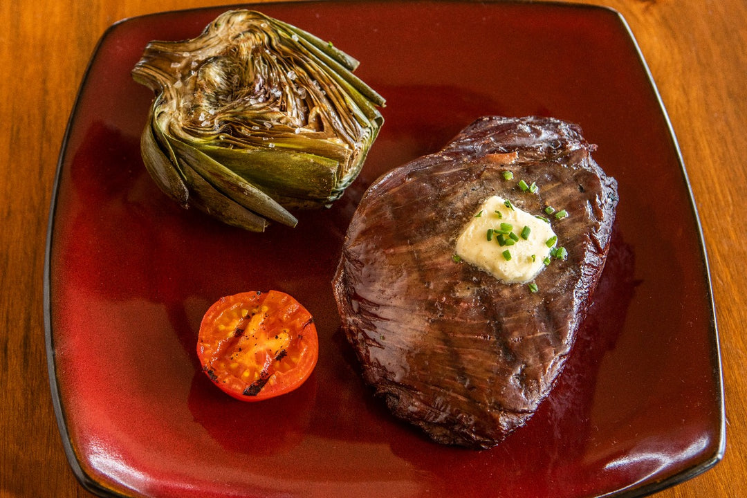 grilled ostrich inside strip with butter and artichoke on the side