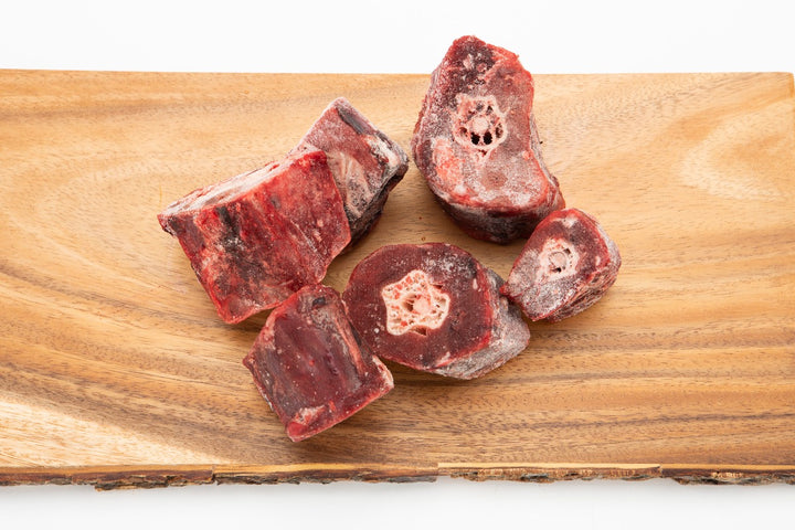 5 raw ostrich necks on cutting board