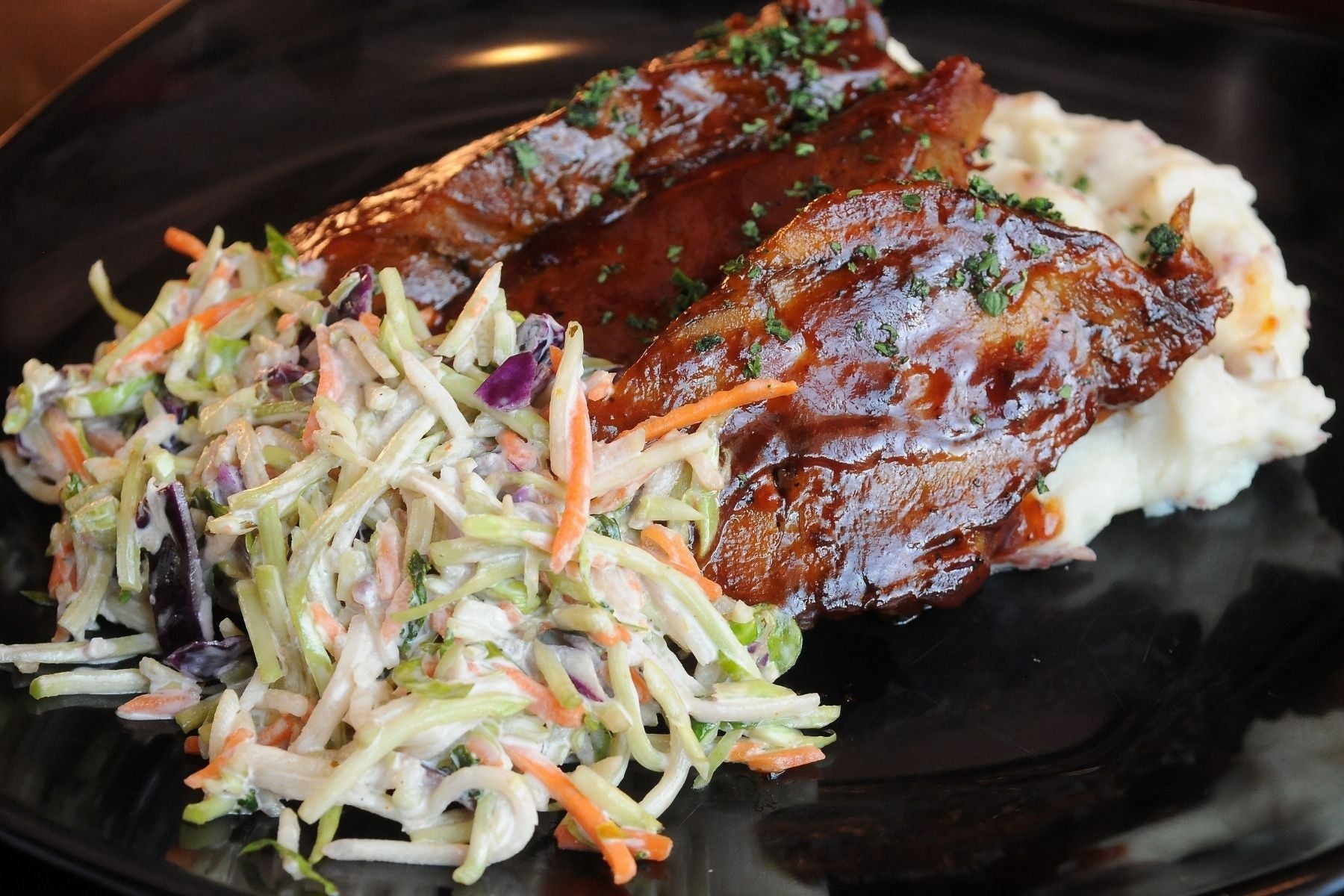 Barbecued lamb riblets with mashed potatoes and coleslaw